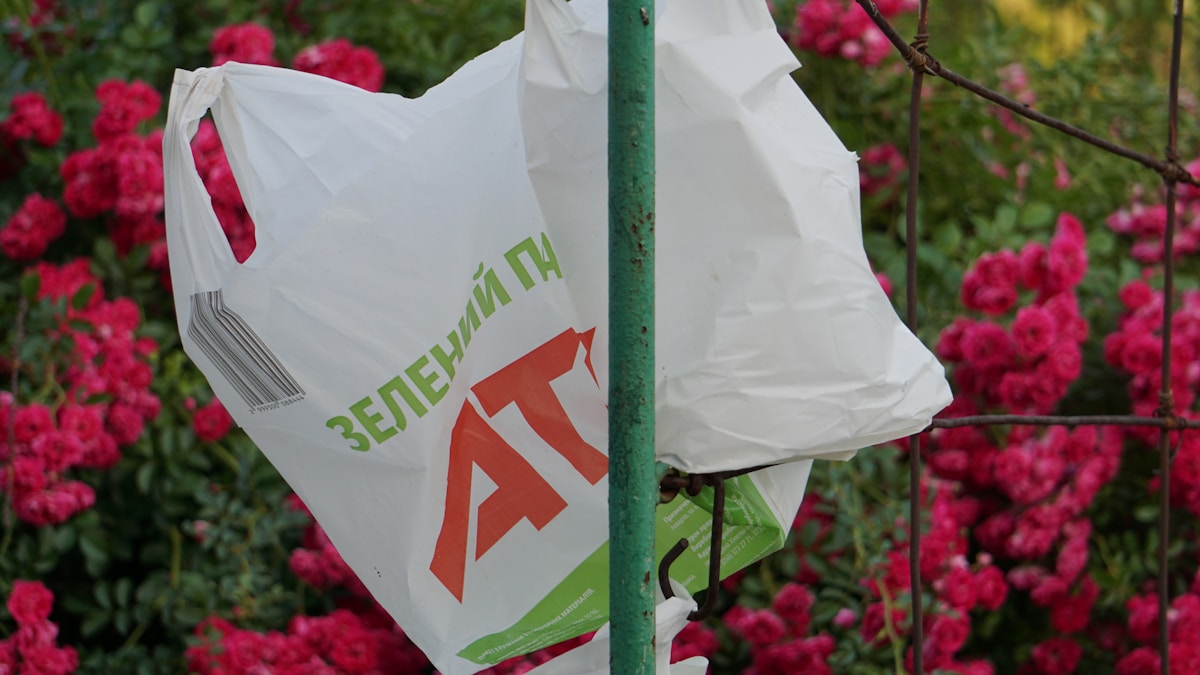 a plastic bag hanging from a green pole