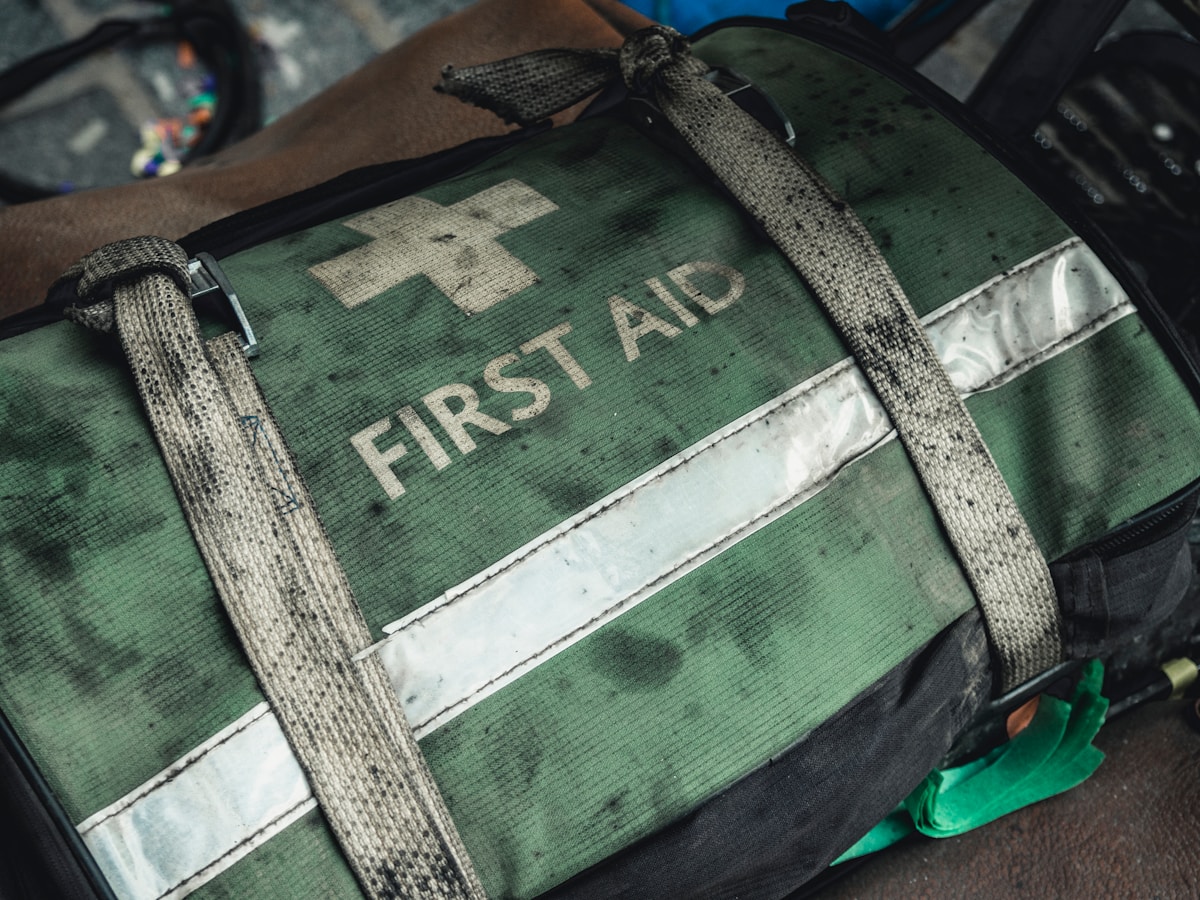Sac de premiers secours vert camouflage avec croix blanche.