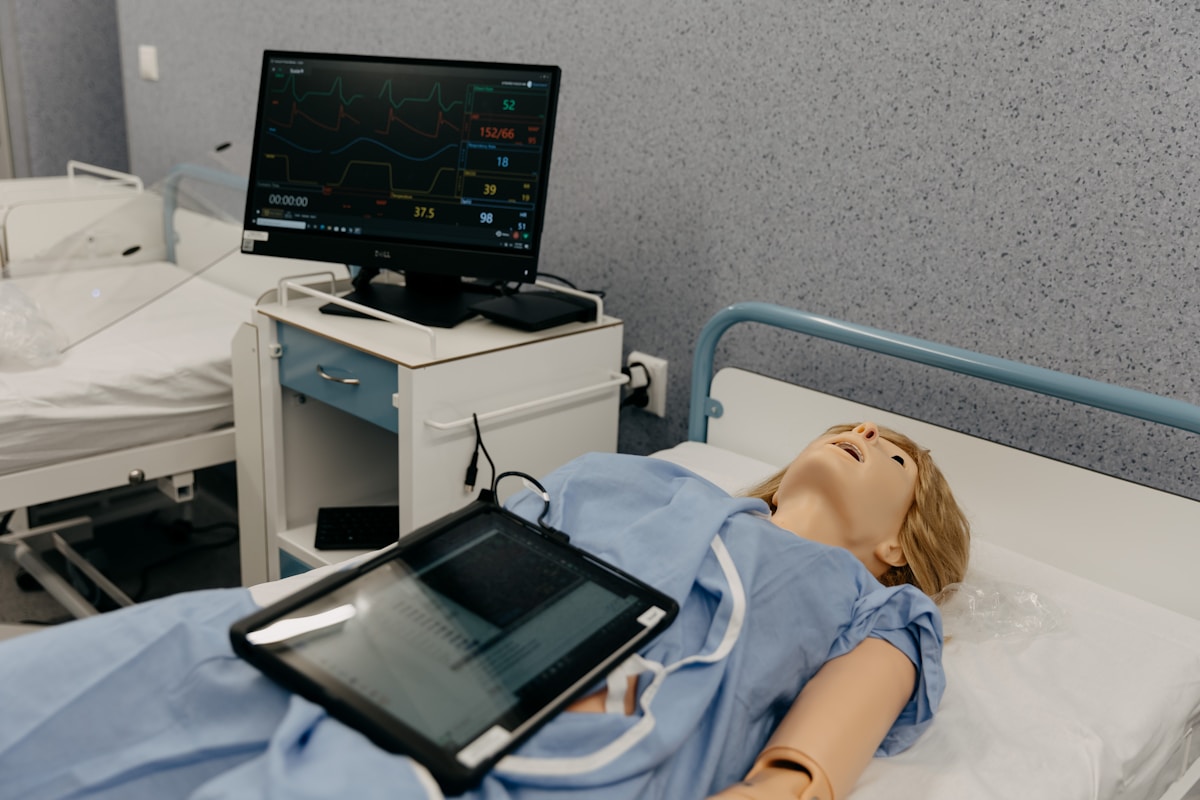 Mannequin médical sous surveillance cardiaque dans une salle d'hôpital.