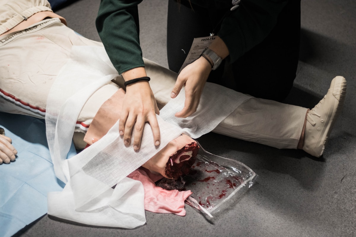 Mains de médecins pansant une blessure sanglante.