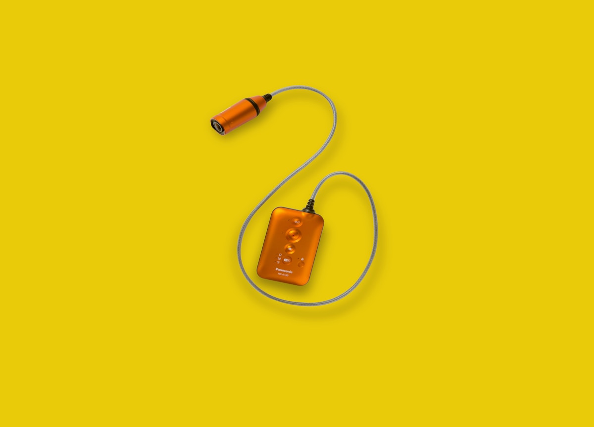 Câble audio orange avec connecteur sur fond jaune.