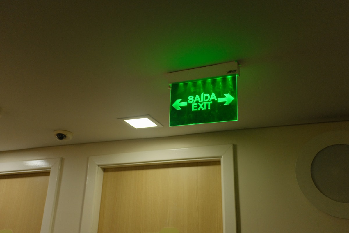 Panneau de sortie de secours vert lumineux dans un bâtiment.