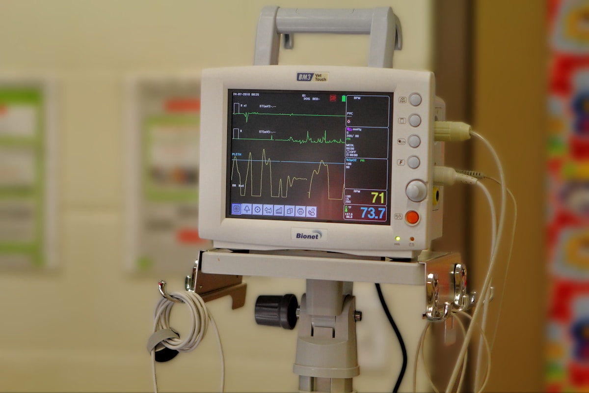 Une chambre d'hôpital avec un moniteur sur un trépied.