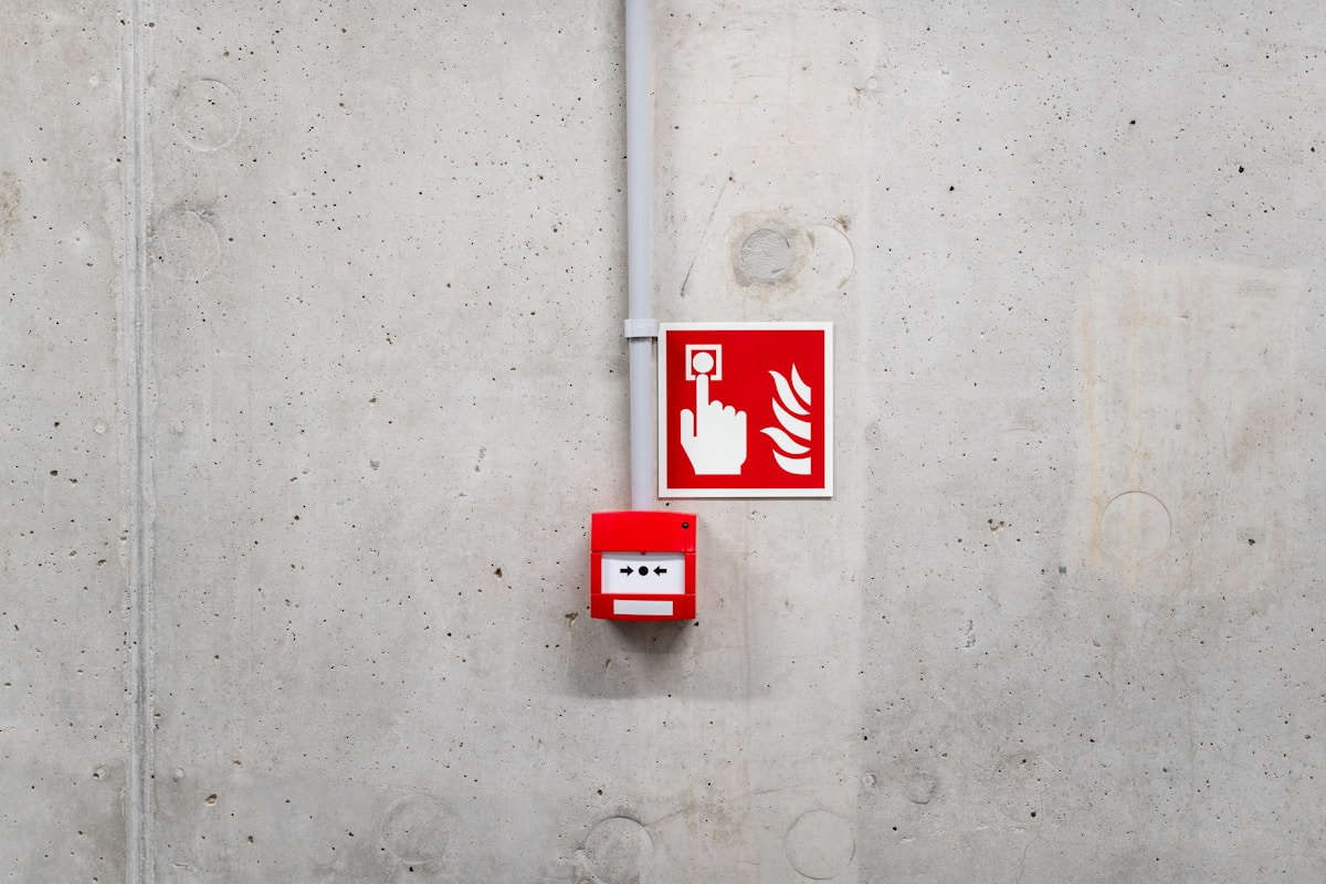 Panneau de sécurité incendie sur un mur de béton texturé.