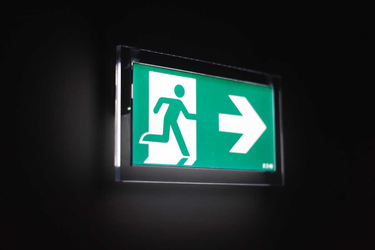 Panneau de sortie de secours vert avec pictogramme de personne courant.