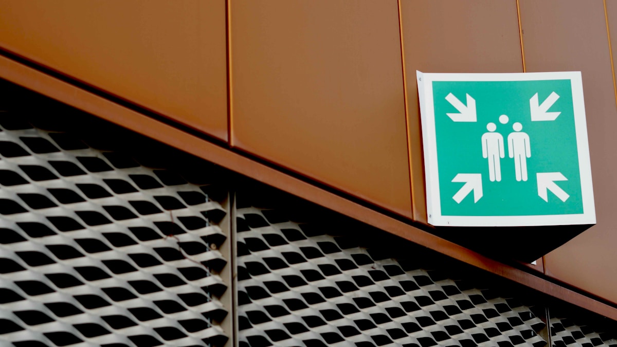 Panneau de signalisation indiquant les toilettes, sur fond de motif géométrique.