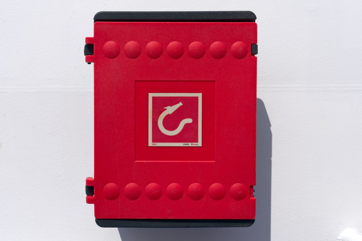 Boîte de rangement rouge avec motifs géométriques et symbole doré.