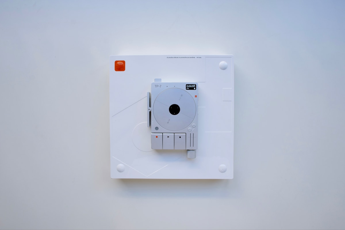 Lecteur de disque compact blanc avec boutons de contrôle.