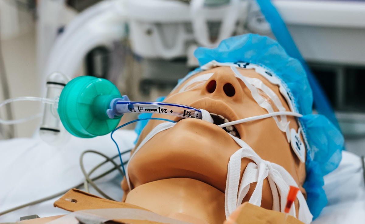 Mannequin médical avec tubes et équipement médical.