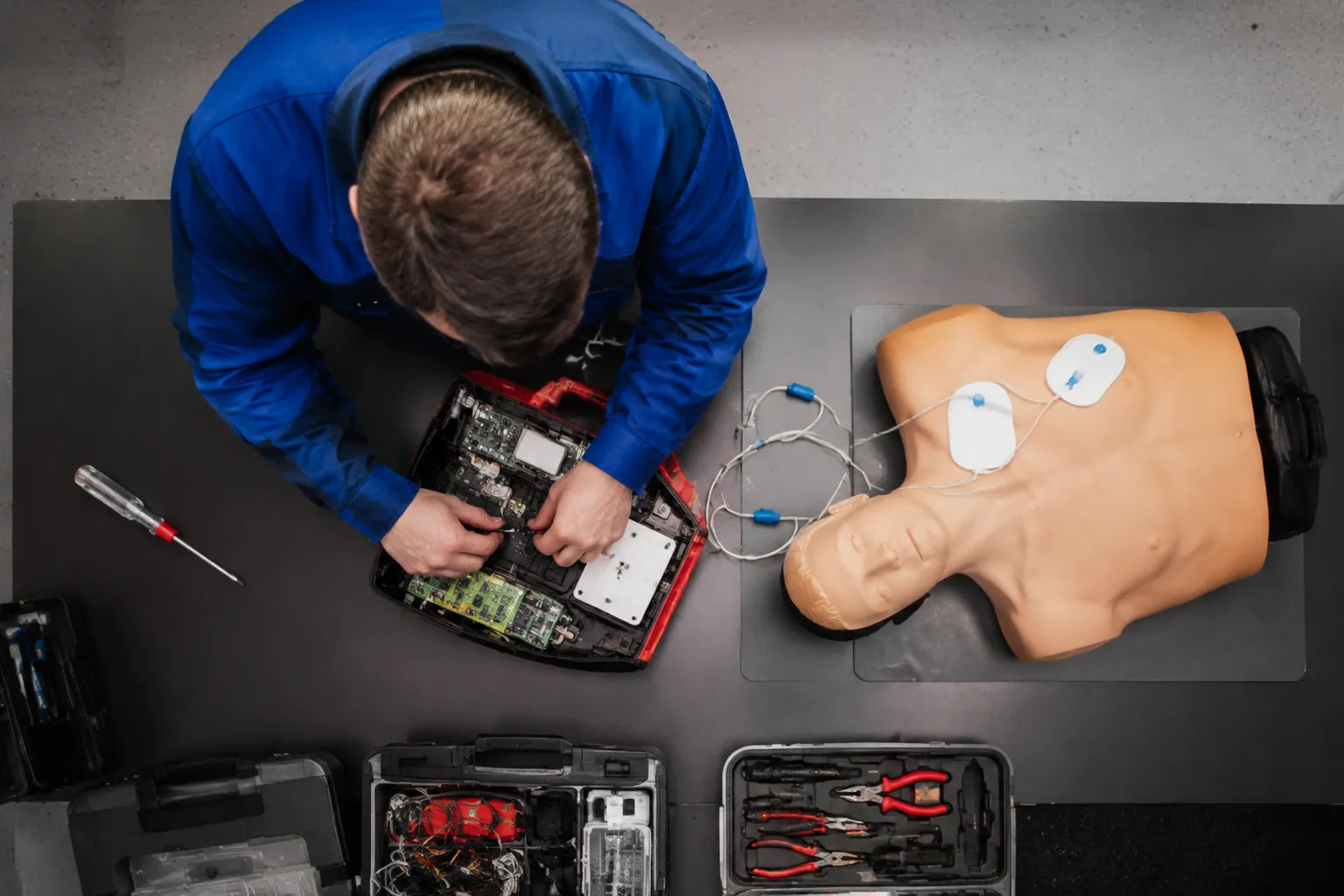 Technicien réparant un ordinateur portable avec des outils.